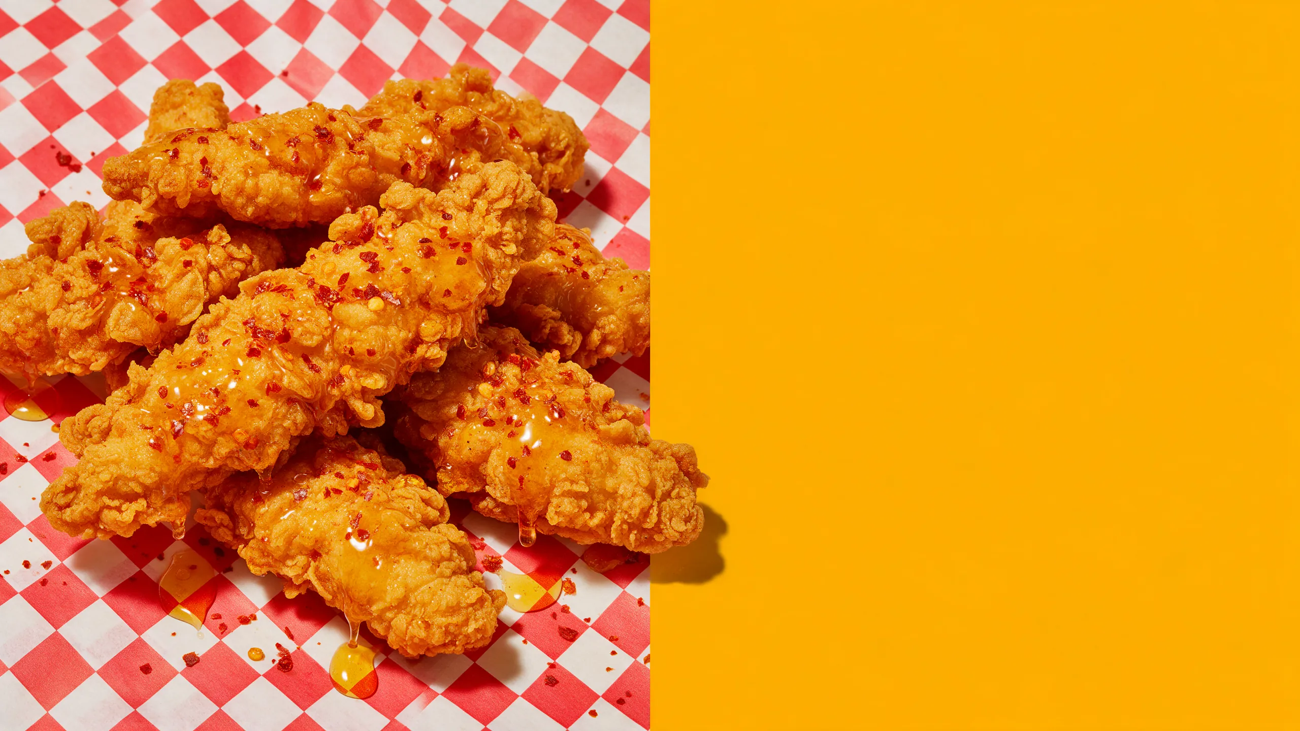 Tenders de poulet croustillant nappés de miel pimenté sur papier à carreaux